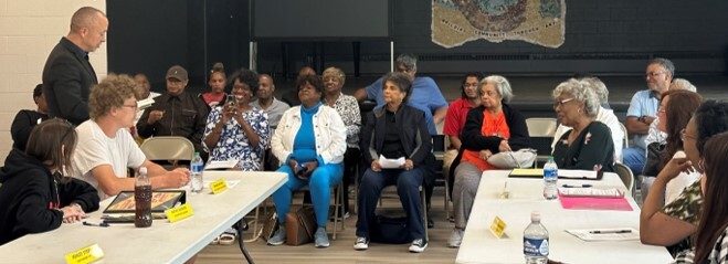 A group of people sat around a room having a discussion. 