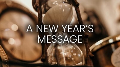 A New Years Message text in front of an hourglass.