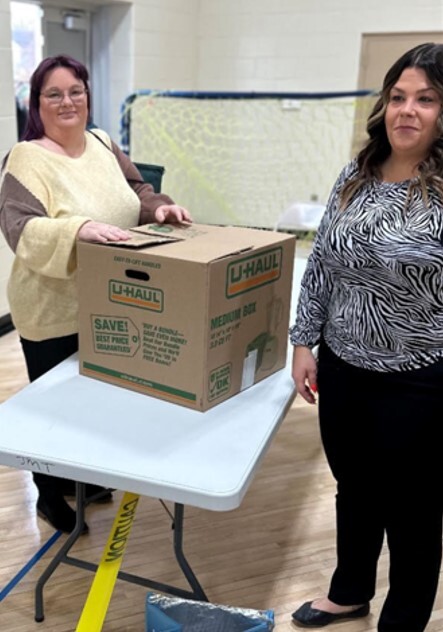 HACR staff and a resident who is receiving a meal kit.