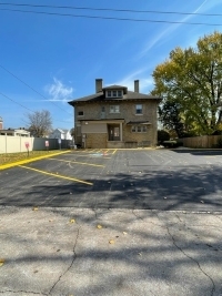Apartments and trees by the repaved parking lot.