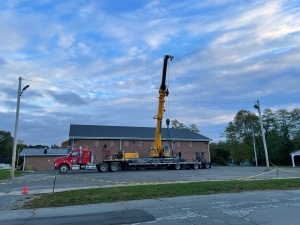 Long shot of a crane in front of a building with the crane extended.