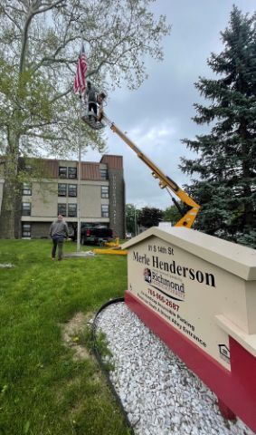 A lift installing the Merle Henderson Flag and Plaque.