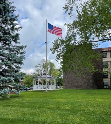 A zoomed out view of the Merle Henderson Flag by the gazebo.