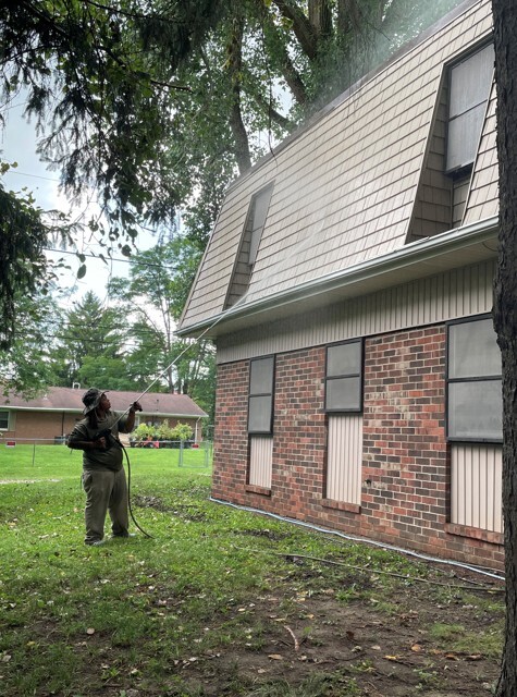 A person power washing the side of a building