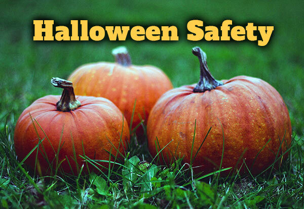Pumpkins in the grass and the text Halloween Safety.