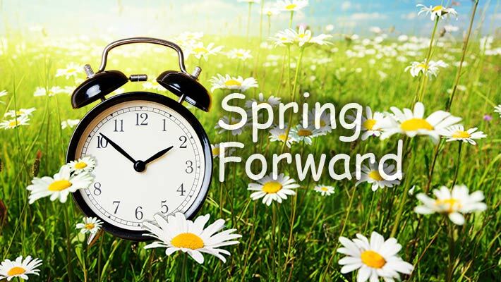Spring forward. An alarm clock surrounded by flowers.