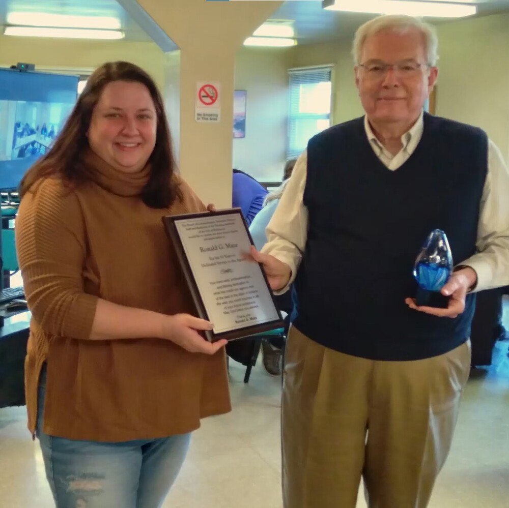 Roxie Deer presenting a plaque to Ronald G. Maze